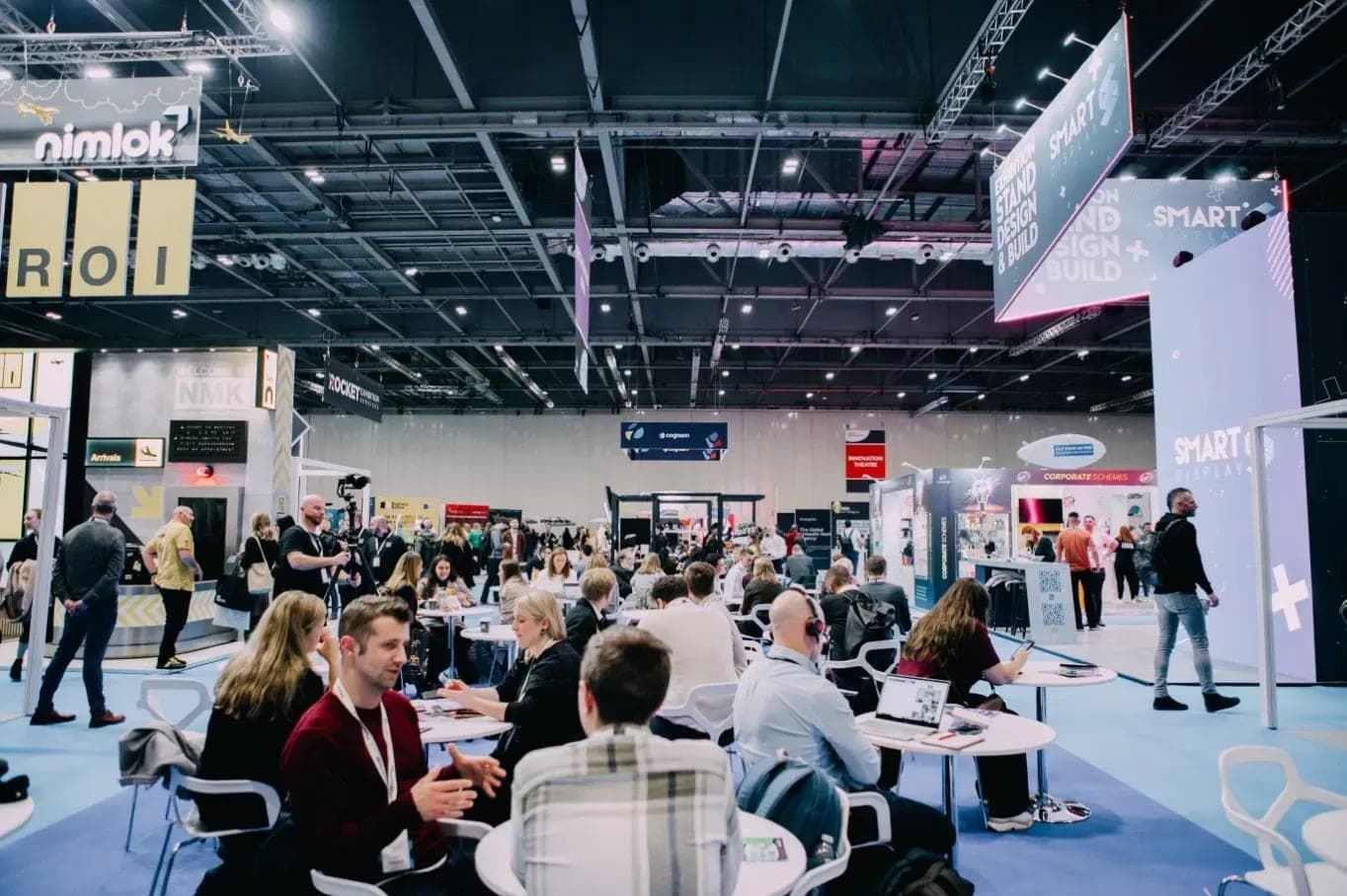 Visitors talking at tables on the show floor at B2B Marketing Live in London