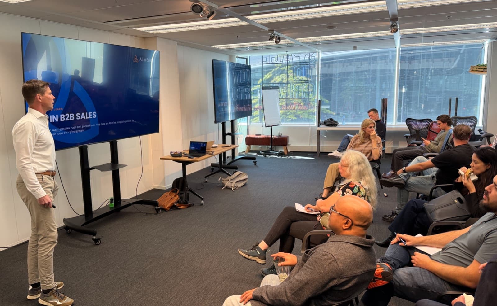 A speaker presenting on AI in B2B sales to a seated audience at a previous Lunch & Learn