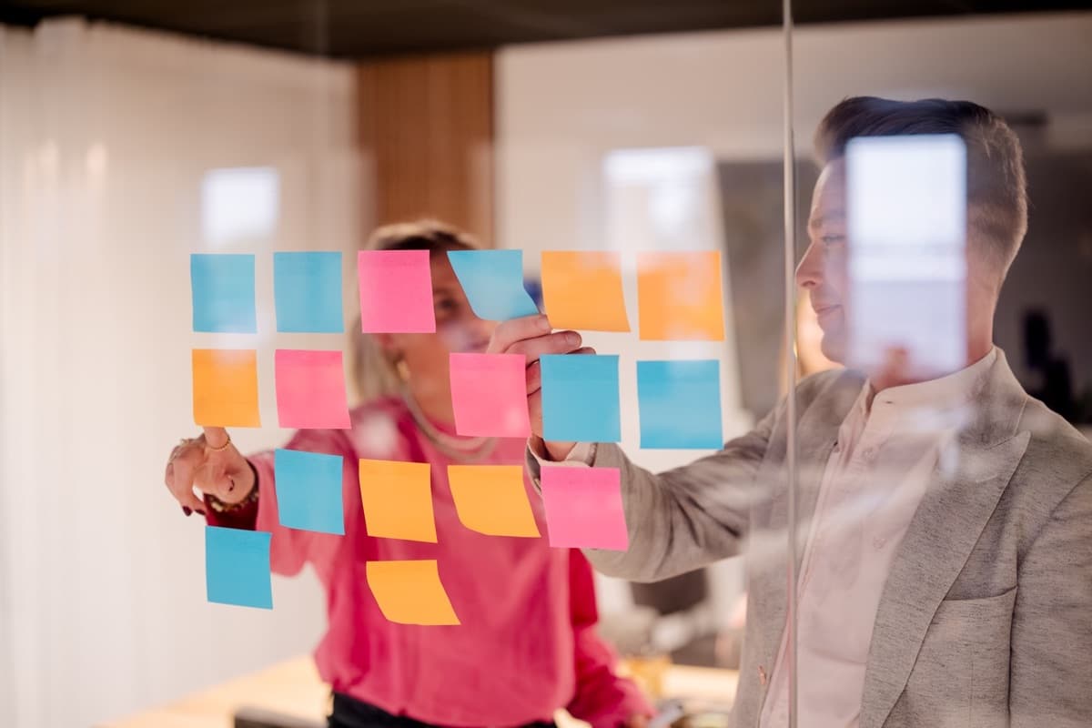 Converseon strategists planning a campaign with sticky notes on a glass wall