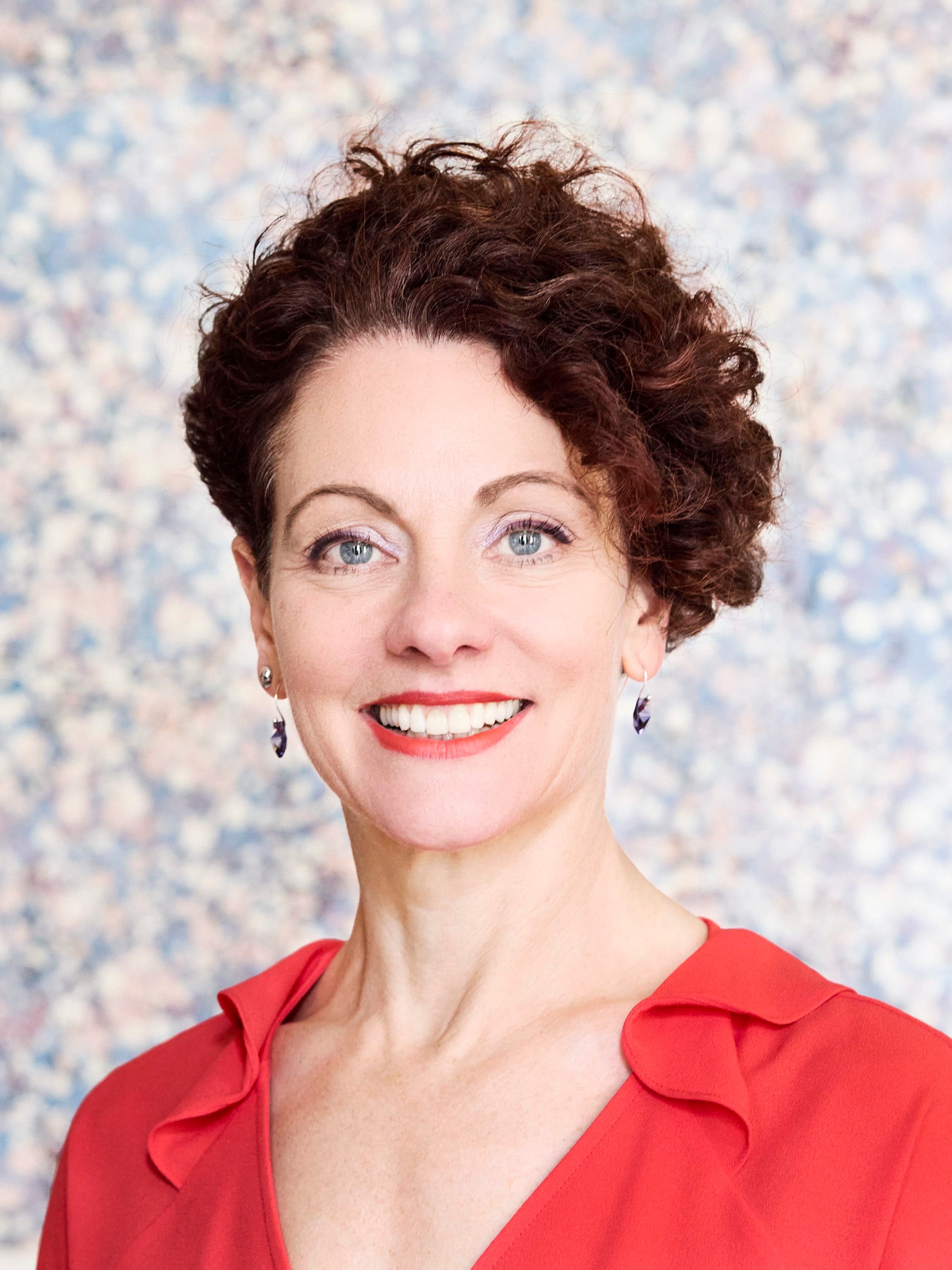 Portrait of Sarah Clay smiling in a red top