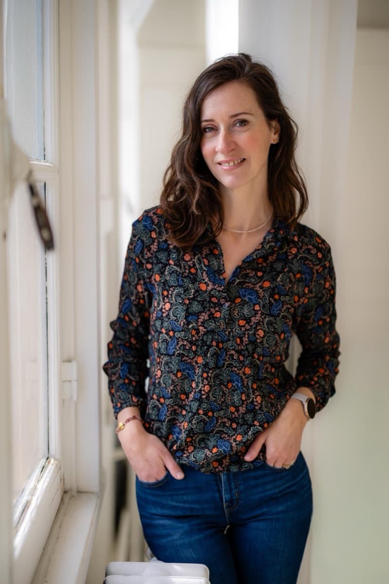Ilse Weijland standing by a window and smiling