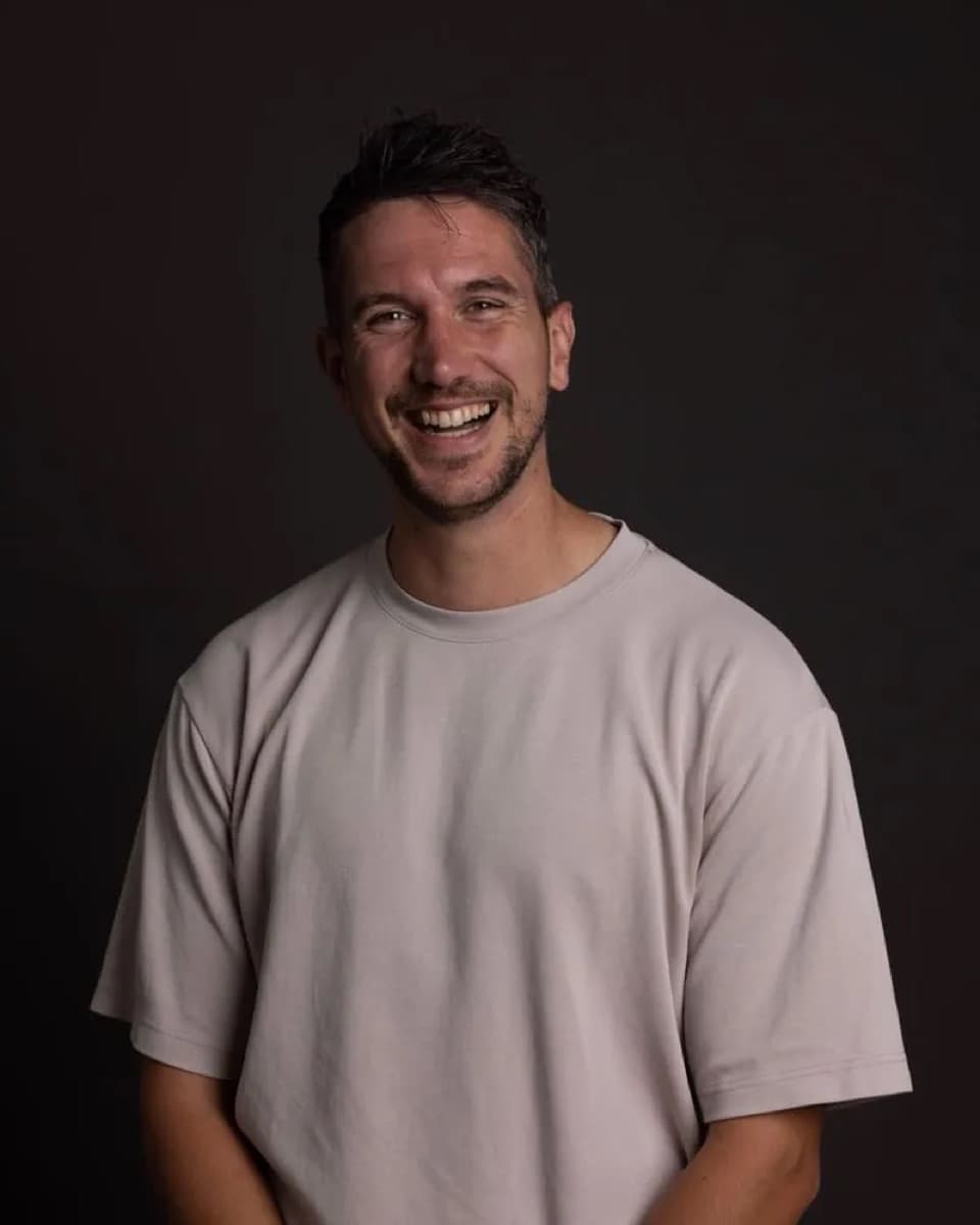 Portrait of Willem Nales laughing against a dark background